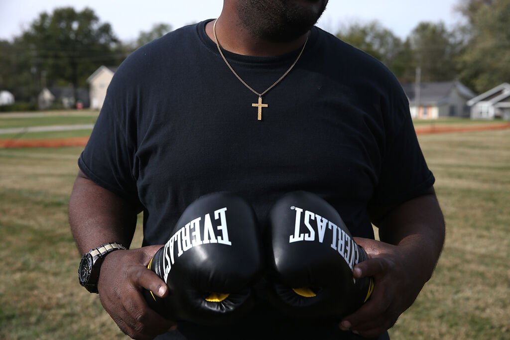 Gary Lewis preps a pair of boxing gloves before a sparring session